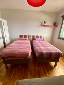 two beds sitting next to each other in a room at casa picasso in Naples