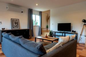 a living room with a couch and a tv at Le Havre du Lac in Brignemont