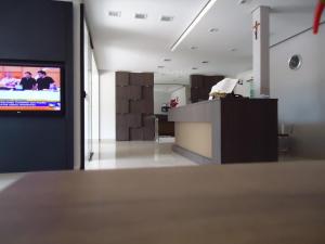 a room with a tv on a wall in a room at Hotel Barril in Primavera do Leste