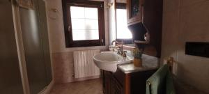 a bathroom with a sink and a window at Delta Liberty BnB in Codigoro