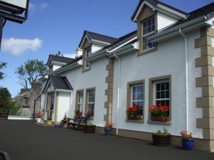 una fila de casas con flores en sus ventanas en Lurig View B&B Glenariffe en Glenariff