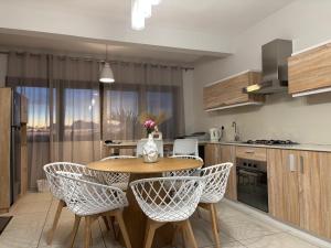 a kitchen with a table and chairs in a kitchen at Ocean Mist - Stunning 3-Bedroom Apartment with Private Rooftop Terrace & Gorgeous Pool in Flic-en-Flac