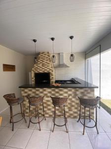锡诺普Recanto Liberdade的厨房设有带椅子和炉灶的酒吧