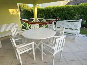 a white table and chairs on a patio at Surfer's Paradise Retreat - Gated Community Townhouse for Surfers & Families in Christ Church +39 photos