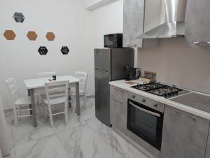 a kitchen with a stove and a table with chairs at Infinity House Catania in Catania