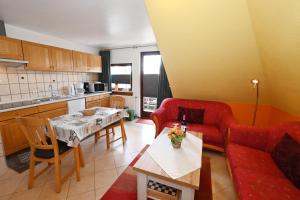 a living room with a red couch and a table at Haus-Lily-Nr-03 in Büsum