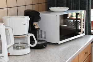 a white microwave sitting on a counter next to a coffee maker at Haus-Lily-Nr-03 in Büsum