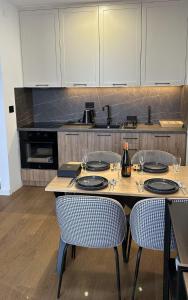 cocina con mesa de madera con sillas y barra en Terra29 apartman, zlatiborski kutak sa besplatnim parkingom, en Zlatibor