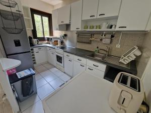 a kitchen with white cabinets and a sink at 450m plage Bourdaines in Seignosse