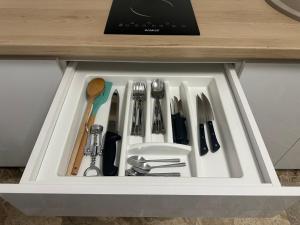 a drawer filled with utensils in a cabinet at Aparthouse 1 in Lugoj