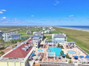 an aerial view of a resort with a pool and the ocean at Cueva de Piratas is Luxury with Beach and Pools in Galveston