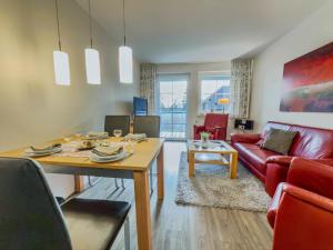 a living room with a red couch and a table at "Landhaus Voss" Typ 2 Nr8 in Staberdorf
