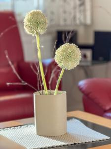 a white vase with flowers in it on a table at "Landhaus Voss" Typ 2 Nr8 in Staberdorf