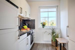 a kitchen with white cabinets and a window at "Landhaus Voss" Typ 2 Nr8 in Staberdorf +22 photos