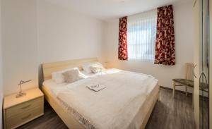 a bedroom with a bed and a window with curtains at "Landhaus Voss" Typ 2 Nr8 in Staberdorf