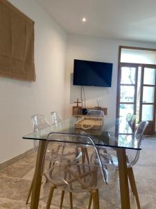 Un comedor con una mesa de cristal y sillas. en Maison Goya Arlésienne, en Arles