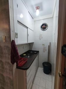 une petite cuisine avec un évier et un comptoir dans l'établissement Apto central com estacionamento, à Poços de Caldas 10 autres photos