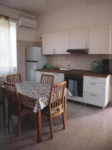a kitchen with a table and chairs and a kitchen with white cabinets at Casa Vacanze Cimorelli in Venafro