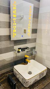 a bathroom with a white sink and a mirror at Holiday Guest House Lahore in Lahore