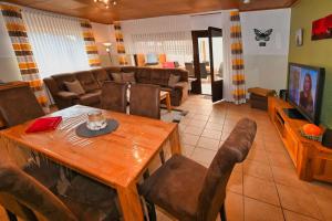 Una sala de estar con una mesa de comedor y un sofá. en Haus Lily Nr.02 bis zu 6 Personen davon max. 2 Kinder, en Büsum