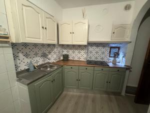 a kitchen with green cabinets and a sink at Casa Montagna in Scanno