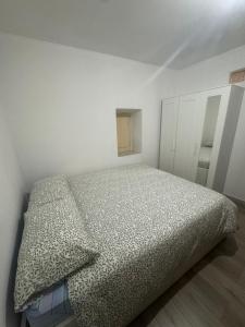 une chambre avec un lit dans une pièce blanche dans l'établissement Casa Montagna, à Scanno