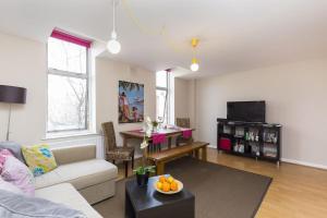 una sala de estar con un sofá y una mesa en Trendy Spacious 1 Bedroom Flat, en Londres