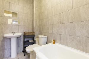 Un baño con lavabo, inodoro y bañera. en Trendy Spacious 1 Bedroom Flat, en Londres 38 fotos más