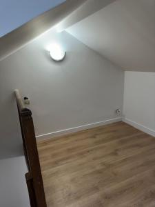 a room with a ceiling with a light and a wooden floor at MEZZANINE 17 Rue de la Fraternité DEUX CHAMBRES AVEC PARKING in Drancy