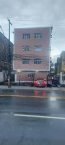 a red car parked in front of a building at Apê Aconchegante in Recife