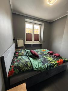 a bedroom with a bed with a colorful comforter and a window at Apartament Centrum 3-pokojowy Klimatyzacja nr 4 in Radom