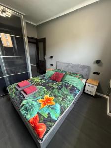 a bedroom with a bed with colorful pillows on it at Apartament Centrum 3-pokojowy Klimatyzacja nr 4 in Radom