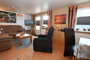 een woonkamer met een bank en een tafel bij Haus-Karin-Ferienwohnung-1 in Büsum