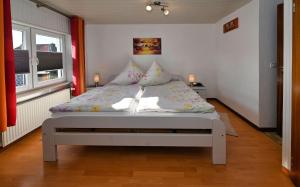 een bed in een kleine kamer met 2 lampen bij Haus-Karin-Ferienwohnung-1 in Büsum