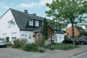 een wit huis met een zwart dak bij Haus-Karin-Ferienwohnung-1 in Büsum