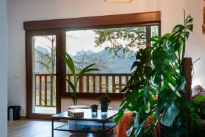 a living room with a table and a large window at Apartamentos Montes Vindios in Cangas de Onís