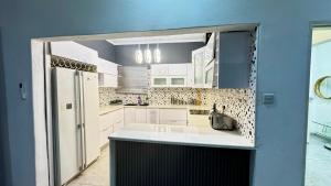 a kitchen with white cabinets and a large sink at CBD sanctuary-self catering in Gaborone