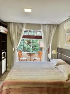 a bedroom with a large bed and a large window at Residencial Jardim dos Pinheiros 279 in Canela