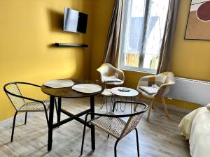 a room with a table and chairs and a bed at La suite du centre ville, proche cœur historique in Bergerac