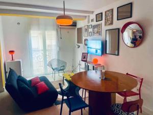 a living room with a table and chairs at Le Nid Des Couleurs in 'Aïn Taya