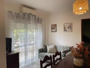 Una sala de estar con un sofá y una ventana. en MantaMar Apartment, en Vila Nova de Cacela