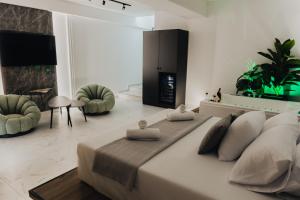 テッサロニキにあるBastasio suites spaの白いベッドルーム(大型ベッド1台、椅子2脚付)
