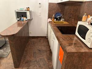 Una pequeña cocina con fregadero y microondas. en Bartholomé 5, en Drancy 17 fotos más