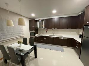 Una cocina con gabinetes de madera y una mesa con sillas. en Casa do Pereiro, en Vieira do Minho