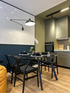 une salle à manger avec une table noire et des chaises noires dans l'établissement Mondrian Luxury Apartment, à Durrës 15 autres photos