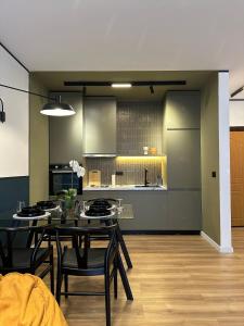 une cuisine et une salle à manger avec une table et des chaises dans l'établissement Mondrian Luxury Apartment, à Durrës
