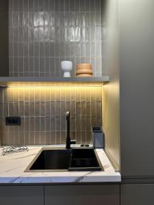 une cuisine avec un évier et un comptoir dans l'établissement Mondrian Luxury Apartment, à Durrës