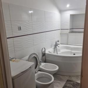 a white bathroom with a toilet and a bath tub at Dom Kopernica 3 in Chełm +19 photos