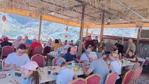 a group of people sitting at tables eating food at Bald Sayt Guest House in Bilād Sayt