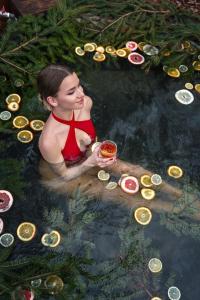 Una mujer en traje de baño rojo sentada en un charco de agua en База відпочинку Forest Stream, en Svalyava